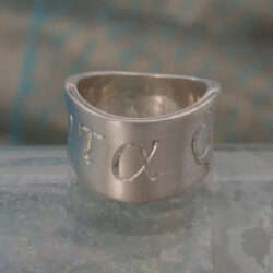 Panta Rhei. Een zilveren ring met Griekse tekst, een uitspraak van de filosoof Heraclitus: Alles stroomt. De ring is golvend en 12 mm breed. Prijs: €245 ,- Panta Rhei