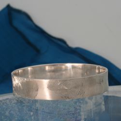 Een zilveren armband met vier vingerafdrukken