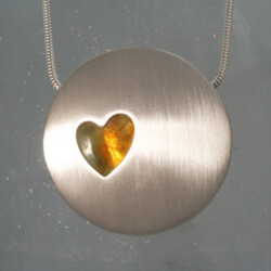 Zilveren hanger met een barnsteen in een hartvorm