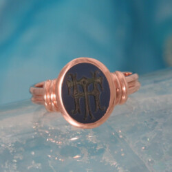 Een roodgouden dames pinkring met een gegraveerde blauwlagensteen