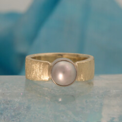 Een ijsmatte geelgouden ring met een grijze cultivé parel