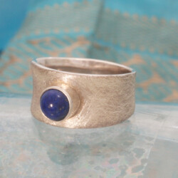 Lapis lazuli ring. De ring is bovenin 11 mm breed en wordt onderin smaller. Prijs: €200,- Matte zilveren ring met lapis lazuli