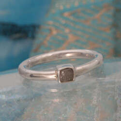 Zilveren ring met ruwe diamant. De steen is 3 x 3 mm en de band is 2 mm breed/dik. Prijs: €200,- Zilveren ring met ruwe diamant
