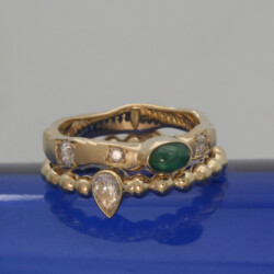 Geelgouden ring met vier briljanten, waarvan één een peervorm en een ovale smaragd