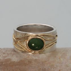 Een matte zilveren ring met geelgouden draden en een jade. De draden zijn gemaakt van een trouwring. Jade wikkelring