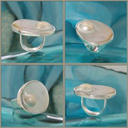 Een glanzende zilveren ring met een blisterparel