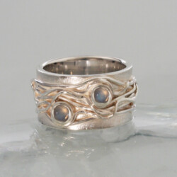 Een zilveren wikkelring met twee maanstenen.