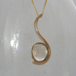 Een geelgouden hanger met een ovale maansteen.