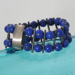 Gezwart zilveren armband met lapis lazuli kralen. De armband is 2,5 cm breed.