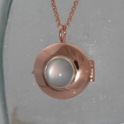 Een roodgoud medaillon van 2,5 cm doorsnede voor twee foto’s, met een maansteen.