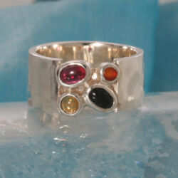 Een zilveren ring als symbool voor het gezin, met geboortestenen van ieder lid van het gezin. Citrien, granaat, carneool en onix. Gezin