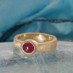 Ijsmatte geelgouden ring met een ronde cabouchon geslepen robijn