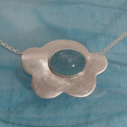 Een zilveren hanger met aquamarijn, geïnspireerd door wolken.