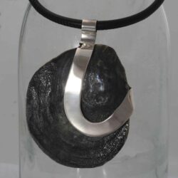Zilveren hanger met een fossiele zwarte oesterschelp, gevonden op 't Rif. 90 mm hoog en 65 mm breed. Prijs is exclusief collier. Prijs: €215,-