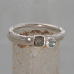 Een zilveren ring met ruwe diamant en een maansteen. De ring kan als aanschuifring gecombineerd worden. € 245,-