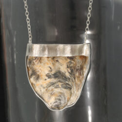 Zilveren hanger/collier met een Japanse oesterschelp. Het collier compleet met ankercollier is 46 cm lang. Prijs: €320,-