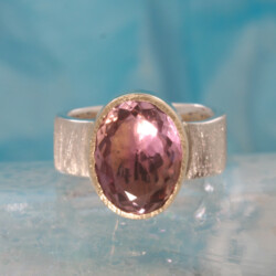 Een zilveren ring met een ametrine gezet in een geelgouden zetkast.