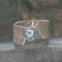Matte zilveren ring met een ronde facet geslepen blauwe topaas