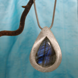 Een matte hanger met een prachtige blauwe labradoriet. De hanger is 50 mm hoog. De prijs is exclusief collier. Prijs: €355,-