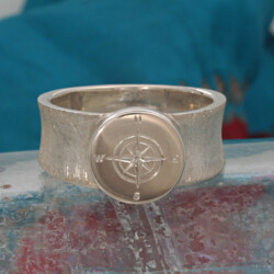 Zilveren ring met een kompas.