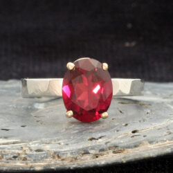 Goed en zilveren ring met rhodoliet, ook wel bekend onder de naam framboosgranaat. De steen is 10 x 8 mm. De zilveren band is hamerslag afgewerkt en de zetting is geelgoud. worden. De ring kan als aanschuifring gecombineerd worden. Prijs: €570,-