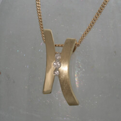 Een geelgouden hanger, ijsmat en glanzend met drie briljanten.