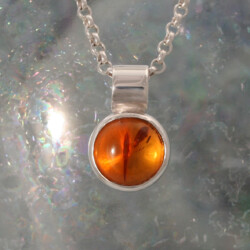 Een zilveren hanger met barnsteen