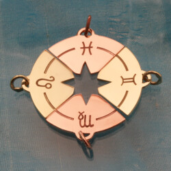 Een gouden hanger, bestaande uit 4 sterrenbeeldhangers, rood en geelgoud, samen vormen ze een windroos. Een prachtig symbool voor veiligheid en geluk. Vroeger werd het vaak gebruikt door zeelieden, omdat het hen hielp de veilige haven terug te vinden.